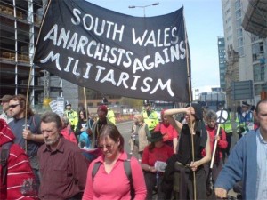 A march, featuring a banner reading 'South Wales Anarchists Against Militarism'